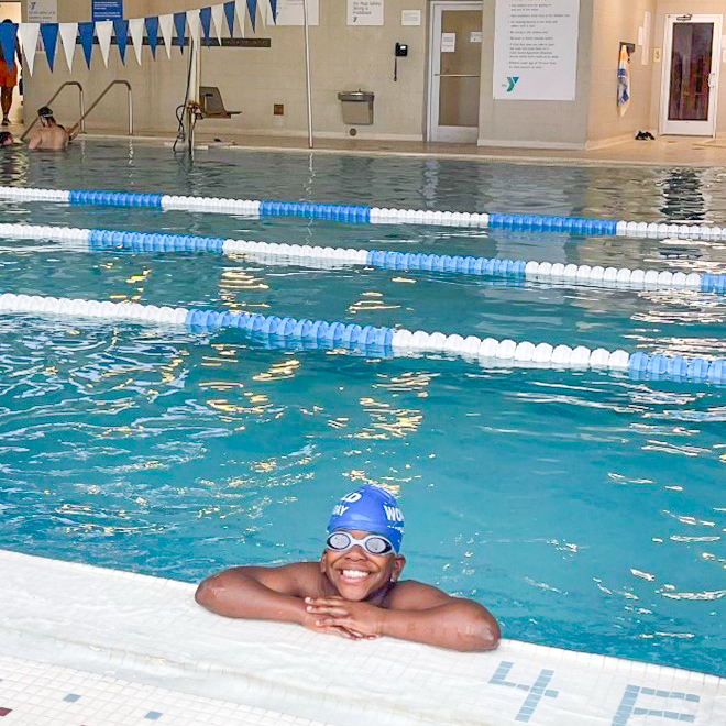 Boy edge of pool smiling